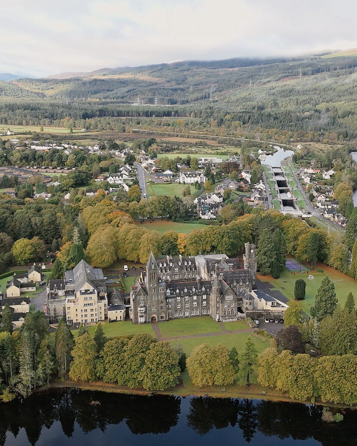 Aerial view of a castle hotel beside a canal and loch in the Highlands